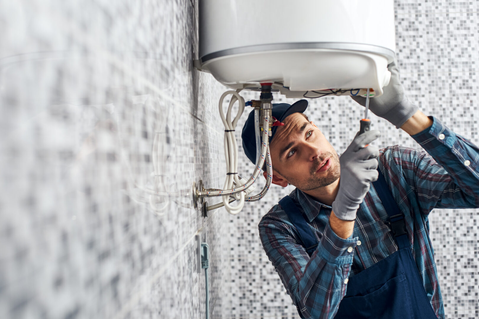 Almost done. Worker set up electric heating boiler at home. Close-up of young handyman