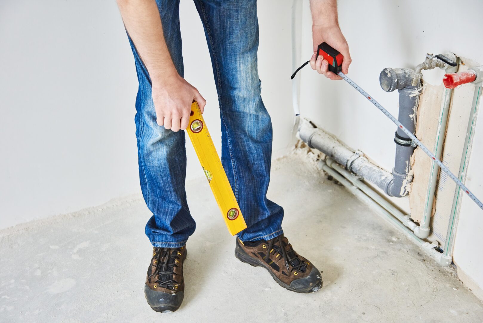 Plumber checks pipe vertical level after installation