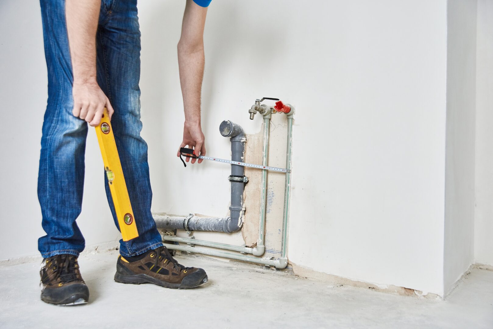 Plumber checks pipe vertical level after installation